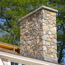 Large fieldstone chimney with 6 thick granite cap