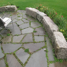 Natural joint bluestone patio with antique granite wall