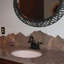 Hand cut, polished granite backsplash skillfully crafted by Chad P. Sanborn in the form of a mountain range