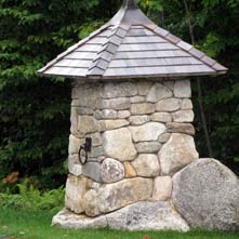One of a pair of custom crafted entry posts atop an existing boulder