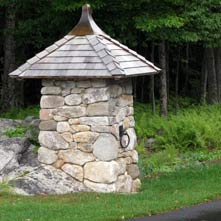 The second of a pair of custom crafted entry posts atop an existing boulder