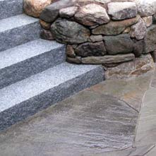 Fieldstone retaining wall with granite steps incorporated into stone work