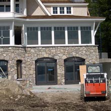 New England fieldstone veneer with granite recessed into arched windows